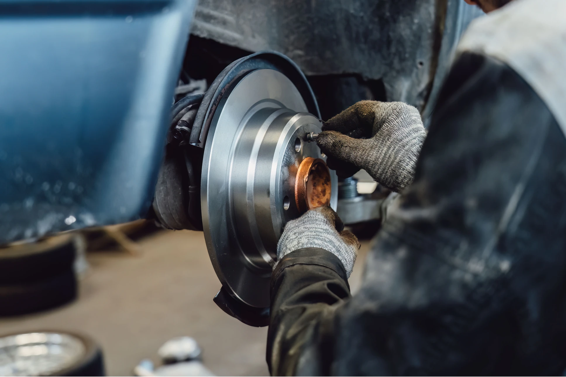 Mécanicien automobile travaillant sur système de freinage d'un véhicule en atelier
