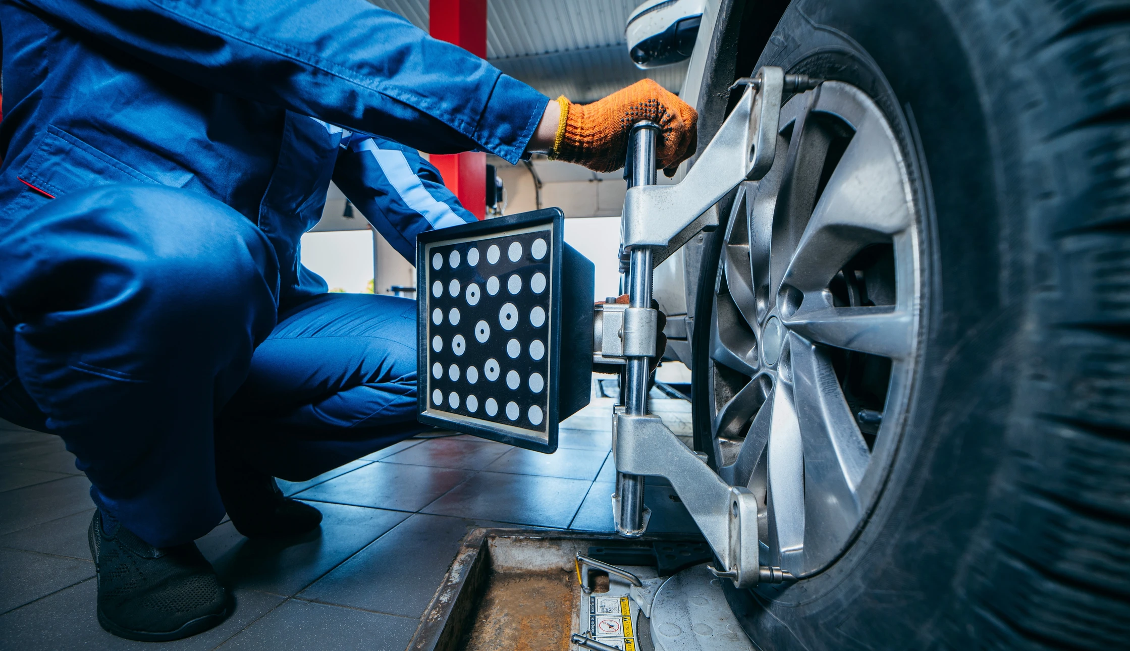 Alignement des roues de la voiture en gros plan sur le stand avec station service d'enregistrement des capteurs